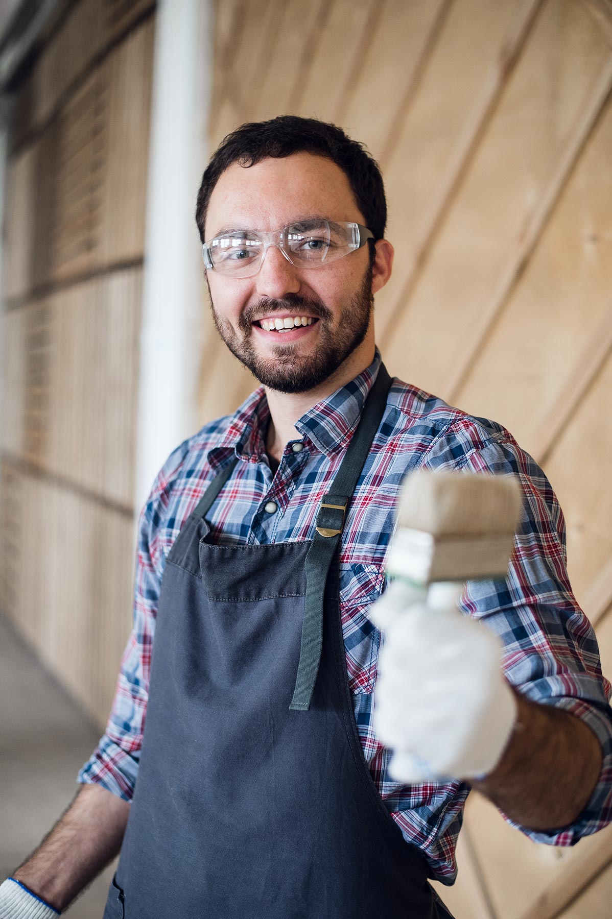 happy-young-painter-holding-paint-brush-and-showin-PYNHRCP.jpg